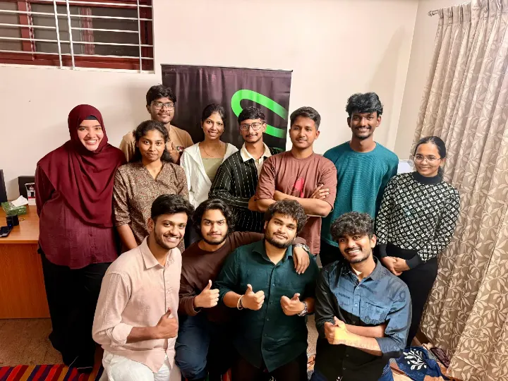 The team gathered together, smiling with thumbs up