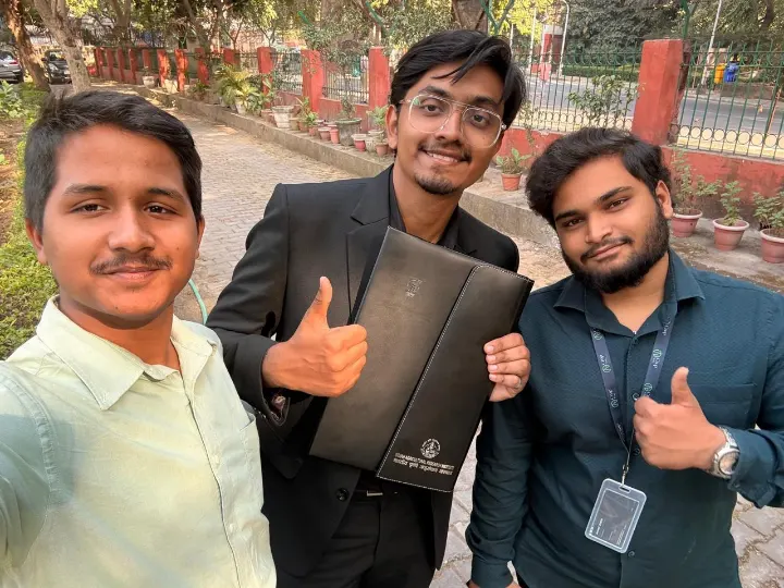 Three team members in a selfie, thumbs up